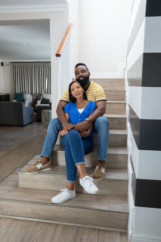 Happy African American Couple Embracing on Staircase at Home