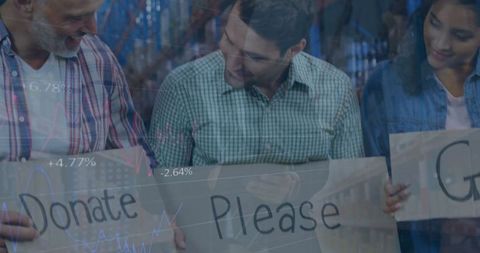 Diverse volunteers in warehouse holding donation signs