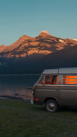 Sunrise Alpenglow on Mountain Lake with Vintage Camper Van Glowing at Shoreline - Vertical Video