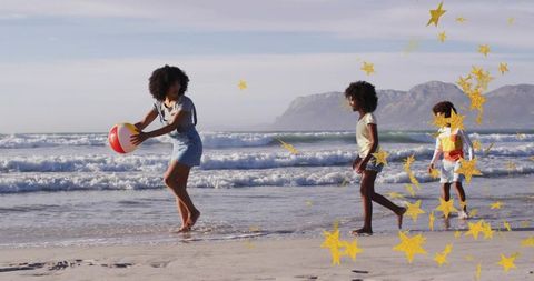 Family playing with beach ball on golden shoreline with kids wearing life jackets