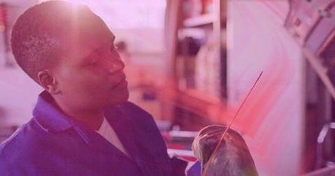 Artisan sculpting wrapped clay with fine brush in studio, focused maker at work