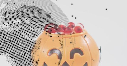 Smiling halloween pumpkin bucket holding red candies on white backdrop halftone globe