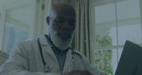 Senior physician reviewing patient records on laptop for telemedicine consultation