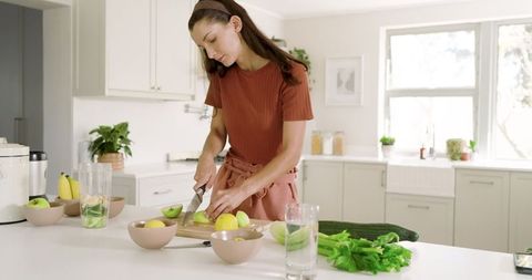 Woman Preparing Fresh Green Apples in Modern Kitchen