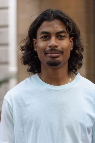 Confident african american man wearing light blue tee and earrings urban portrait headshot