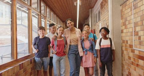 Diverse Group of Students and Teacher Walking Together in School Hallway