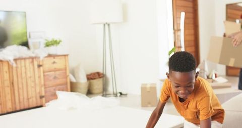 Family moving day child playing and unpacking in sunlit living room