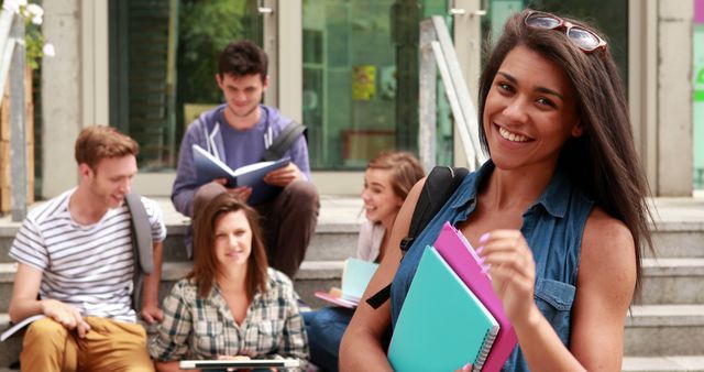 Smiling Female Student Holding Notebooks with Friends Discussing Outdoors - Download Free Stock Images Pikwizard.com