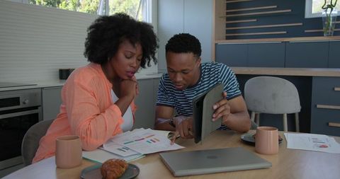 Young Couple Collaborating on Finances in Kitchen