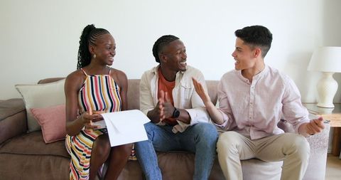 Friends Sharing Snacks and Tablet While Laughing Joyfully Indoors