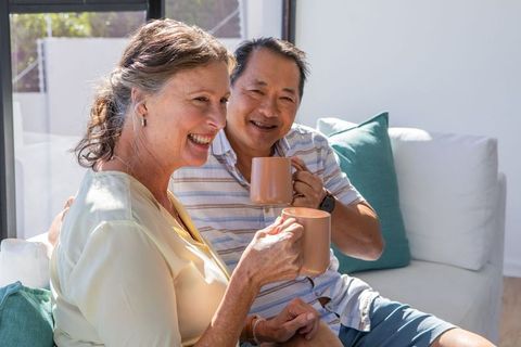 Diverse senior couple enjoying coffee together at home