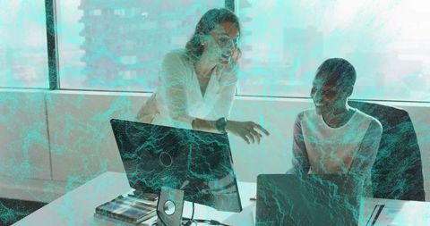 Collaborating Women in Modern Office Examining Data on Monitor