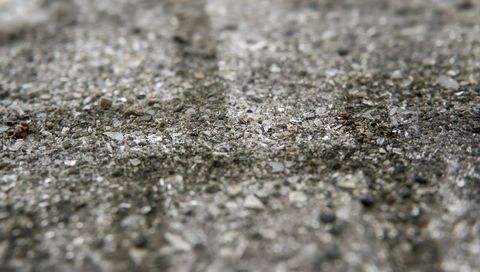 Macro coastal gravel and crushed shells texture on sandy shoreline with pebbles