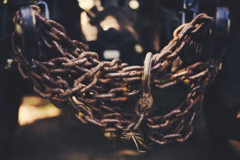 Rusty chains hanging on industrial equipment outdoors