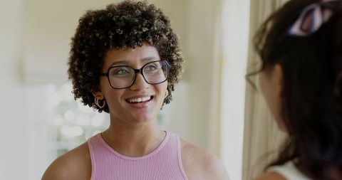 Smiling Woman with Glasses Engaging in Friendly Home Conversation