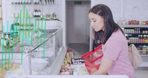 Woman selecting fresh pastries at deli counter with red shopping basket and chalkboard