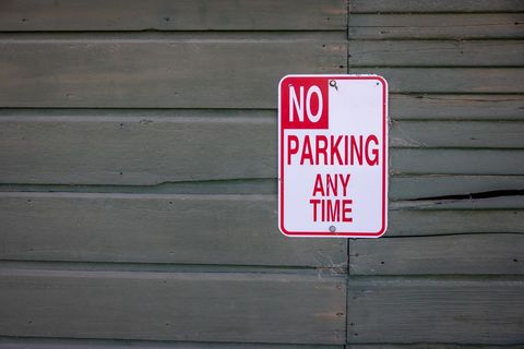 No parking any time sign on wooden wall