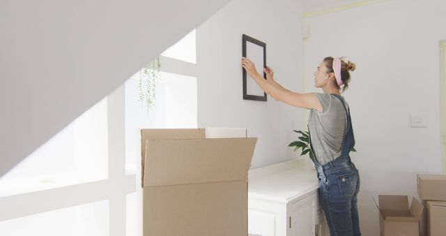 Woman Renovating Home Hanging Picture Frame on Wall - Download Free Stock Images Pikwizard.com