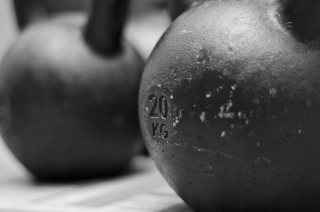 Close-up view of two heavy kettlebells used for weightlifting and strength training in a gym. The 20 kg mark is clearly visible, indicating the kettlebells' weight. Suitable for use in fitness blogs, gym advertisements, and health magazines to promote weightlifting and strength training equipment.