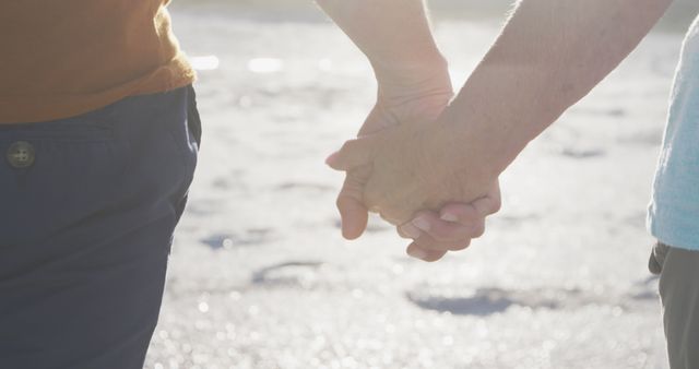 This close-up portrays two people holding hands, creating an intimate and touching visual of love and unity on a beach. Ideal for use in themes related to romance, relationships, companionship, support, and affection. Suitable for blogs, relationship advice websites, social media posts, and use in advertising romantic getaways or counseling services.