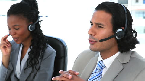 Professional Business Team Using Headsets for Client Communication