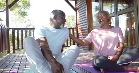 Senior Couple Enjoying Yoga and Conversation on Sunny Porch