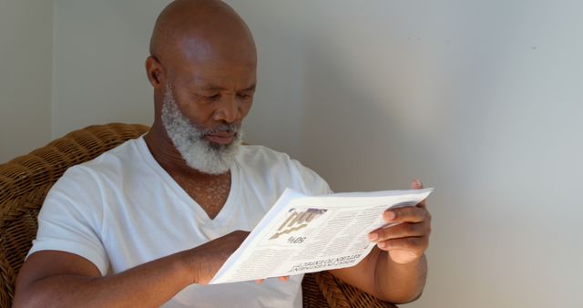 Front view of black mature man reading newspaper at home - Download Free Stock Photos Pikwizard.com