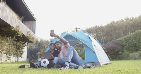 Father Son Taking Selfie Lawn Camping with Tech Gadgets