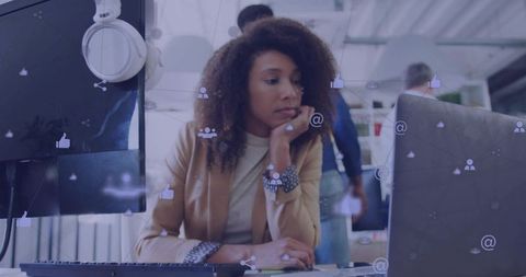 Monitoring social media engagement at modern open-plan workstation by thoughtful professional