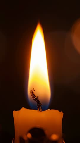 Vertical video flickering candle flame on burnt wick with wax drips, ambient meditation loop