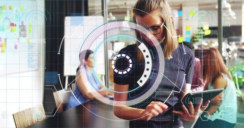 Woman interacting with augmented reality tablet and HUD in collaborative modern office hub