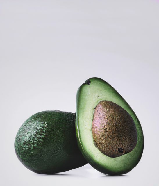 Close up of green avocados on grey background created using generative ai technology. Vegetables, food and nutrition concept, digitally generated image.