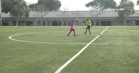 Focused youth soccer athletes mid-practice on greenfield