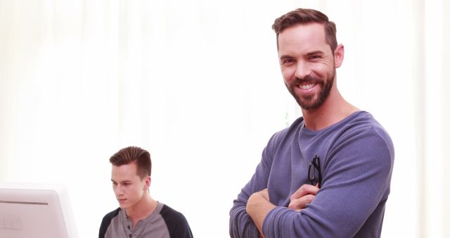 Young Man Standing Confidently in Casual Office Setting - Download Free Stock Images Pikwizard.com