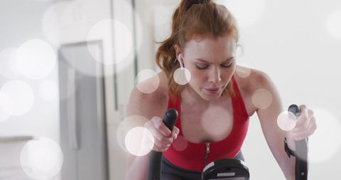 Focused Woman Exercising on Stationary Bike Indoors