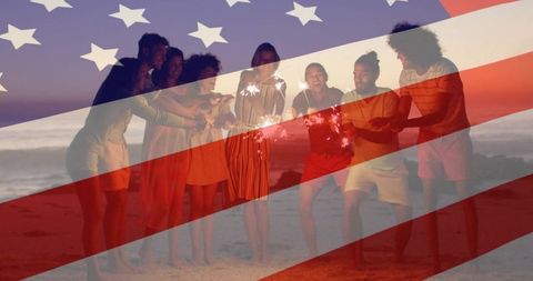 Friends celebrating fourth of july on beach at dusk holding sparklers with us flag overlay