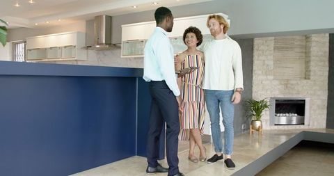 Real estate agent shows couple around modern home interior