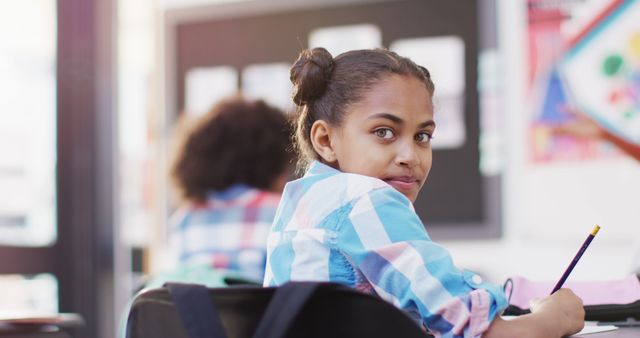 Young African American Student Smiling in Classroom, Holding Pencil - Download Free Stock Images Pikwizard.com