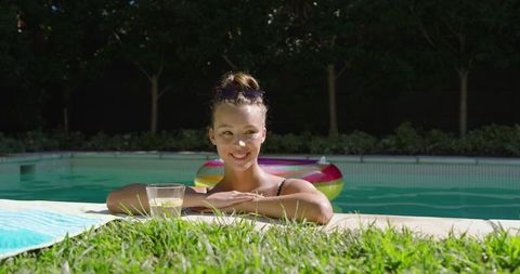Woman Relaxing by Backyard Pool with Inflatable Ring