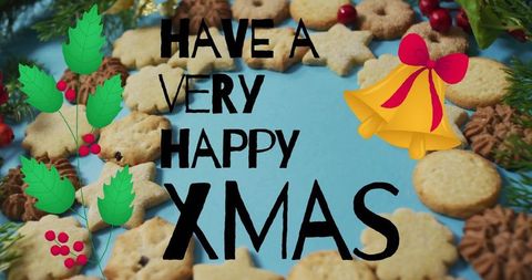 Handwritten xmas greeting on blue backdrop with shortbread cookie wreath, holly and bells