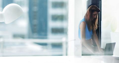 Hispanic Businesswoman Working on Laptop in Modern Office