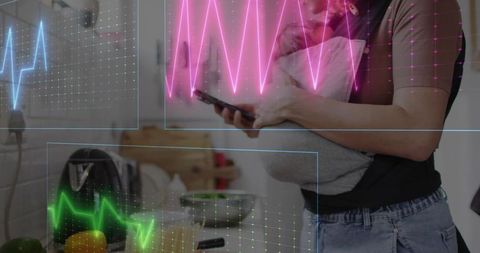 Cradling swaddled baby while checking smartphone with neon health data in kitchen