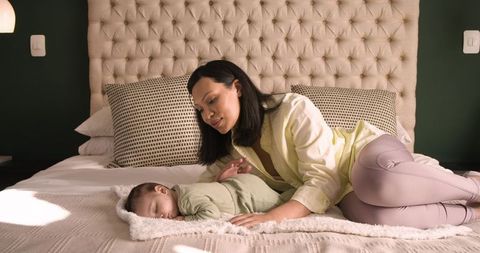 Mother caring for sleeping child in cosy bedroom setting