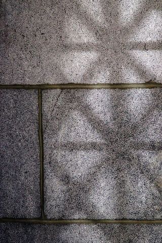 Shadow play on stone wall showing decorative pattern