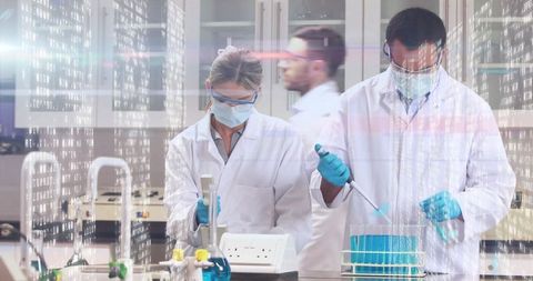 Scientists Conducting Precision Experiment with Pipettes in Modern Laboratory