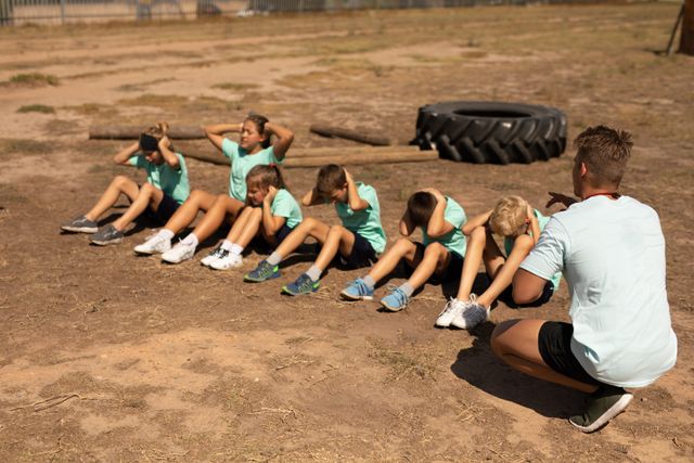 Children Doing Crunches at Outdoor Boot Camp with Fitness Coach - Download Free Stock Images Pikwizard.com