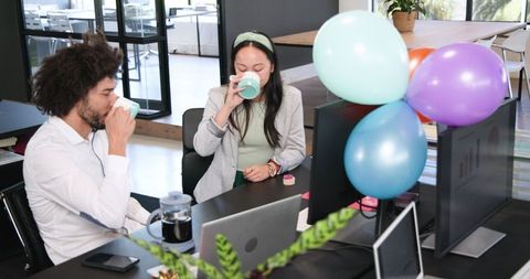 Colleagues Enjoying Office Celebration with Balloons