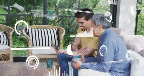 Father and son sharing tablet in sunroom while exploring digital hud and data visualizations