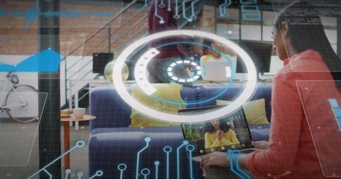 Woman working on laptop in co-working lounge with augmented reality HUD overlay while video calling