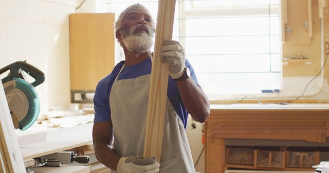 African american male carpenter looking and choosing wooden plank in a carpentry shop - Download Free Stock Photos Pikwizard.com